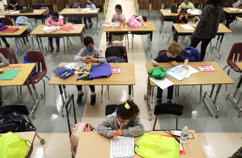 First-graders do schoolwork in the auditorium at Warner Avenue Elementary in Westwood on April 16. Warner Avenue was among 61 elementary and 11 early-education L.A. Unified campuses that opened last week for the first time in over a year.(Christina House / Los Angeles Times)