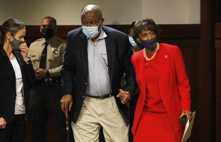 Then-Los Angeles County Dist. Atty. Jackie Lacey holds hands with her husband, David, on the way to a news conference after her defeat at the polls in November. (Al Seib / Los Angeles Times)