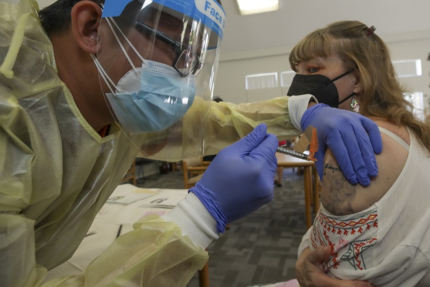 Registered nurse Bryan Phan gives a Johnson & Johnson COVID-19 vaccination to Linda Davis, 60, in Lakewood on March 31, 2021. (Irfan Khan / Los Angeles Times)