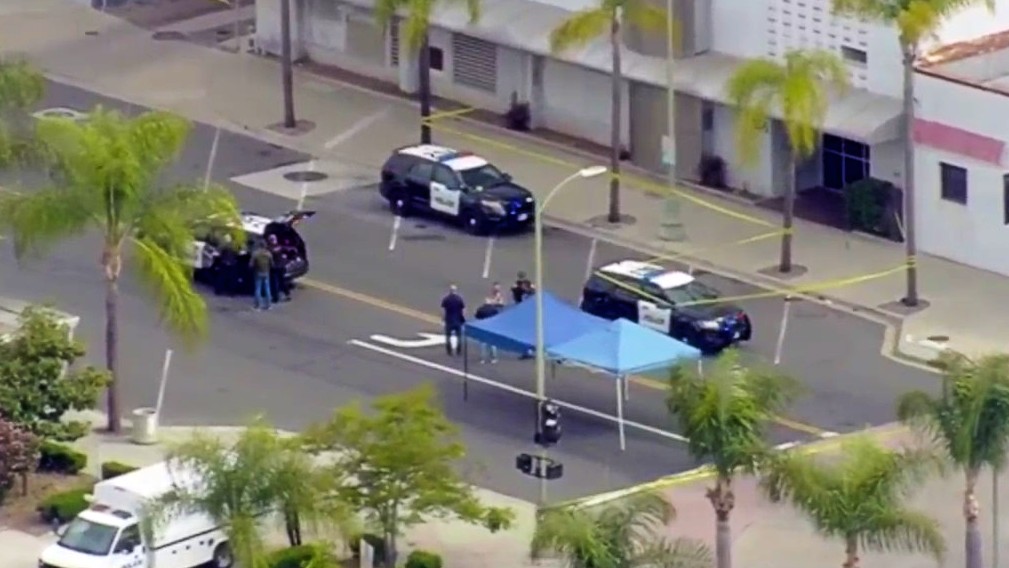 Investigators work at the scene of a police shooting in Escondido, where officials say an officer shot a man who had been seen with a "large metal object," but shared few further details.