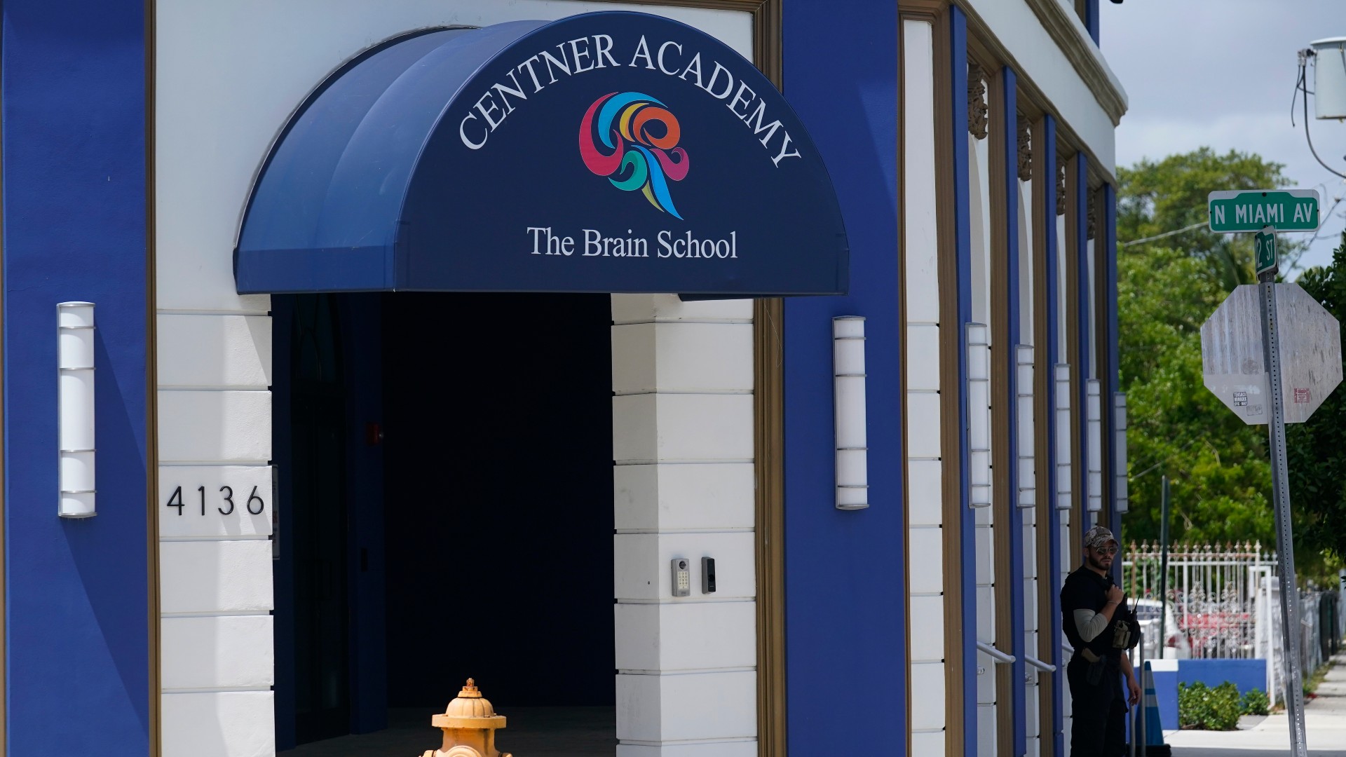 A security guard walks the perimeter of the Centner Academy, Tuesday, April 27, 2021, in Miami. The private school founded by an anti-vaccination activist in South Florida has warned teachers and staff against taking the COVID-19 vaccine. The Centner Academy sent parents a letter Monday informing them of a new policy against employing anyone who has had the shots. (AP Photo/Marta Lavandier)