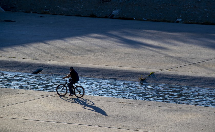 A cyclist rides along the Los Angeles River in South Gate in an undated photo. (Brian van der Brug / Los Angeles Times)