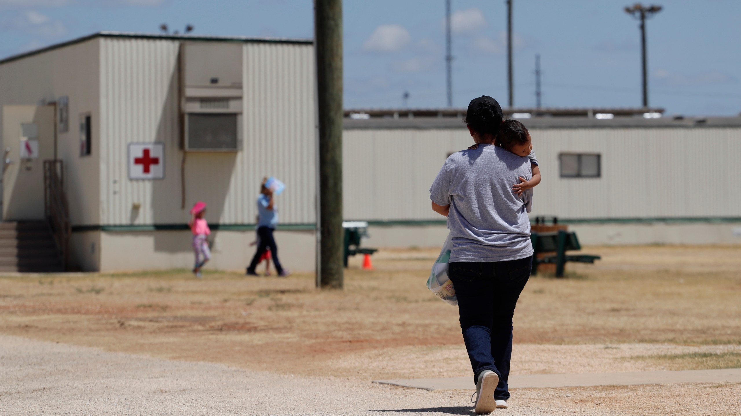 Immigrants seeking asylum walk at the ICE South Texas Family Residential Center, Friday, Aug. 23, 2019, in Dilley, Texas. (AP Photo/Eric Gay, File)