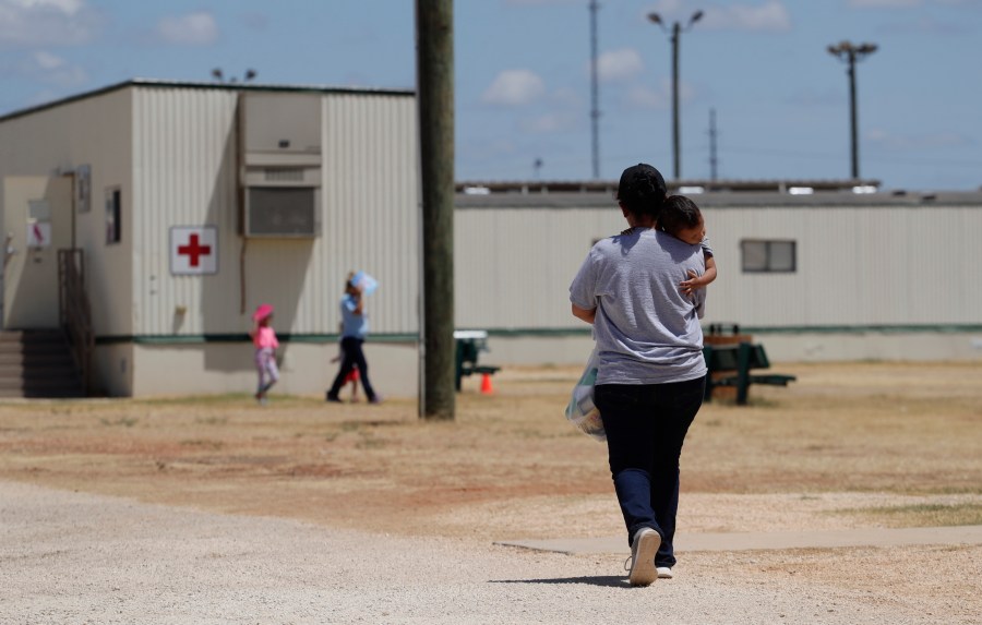 Immigrants seeking asylum walk at the ICE South Texas Family Residential Center, Friday, Aug. 23, 2019, in Dilley, Texas. (AP Photo/Eric Gay, File)