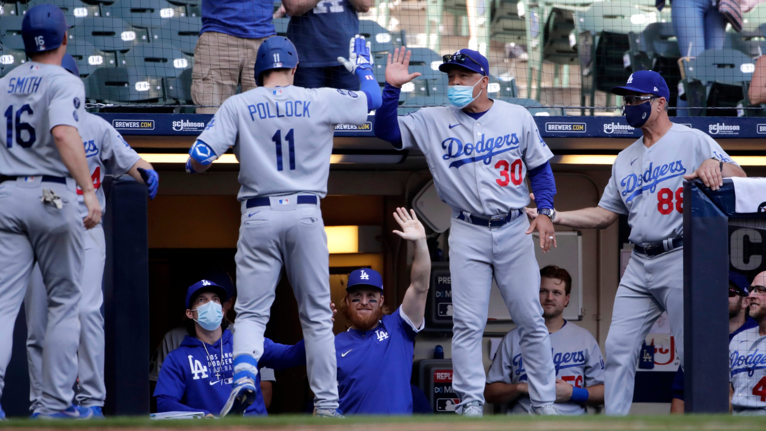 Los Angeles Dodgers' AJ Pollock (11) is congratulated by manager Dave Roberts (30) after hitting a three-run home run during the sixth inning of a baseball game against the Milwaukee Brewers, Sunday, May 2, 2021, in Milwaukee. (AP Photo/Aaron Gash)