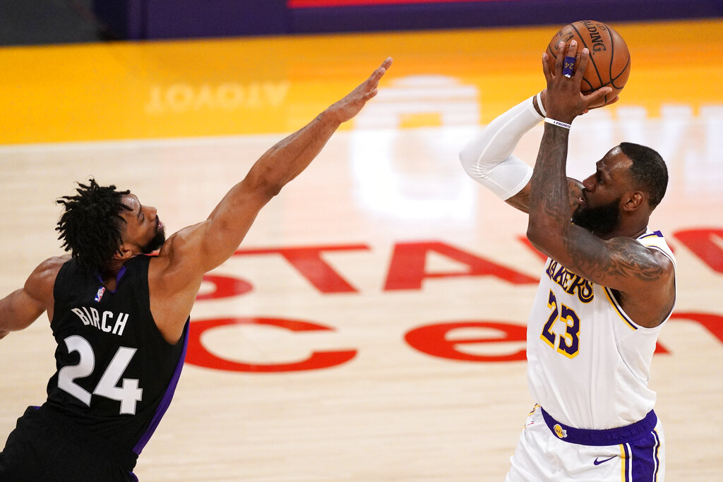 Los Angeles Lakers forward LeBron James, right, shoots as Toronto Raptors center Khem Birch defends during the first half of an NBA basketball game Sunday, May 2, 2021, in Los Angeles. (AP Photo/Mark J. Terrill)