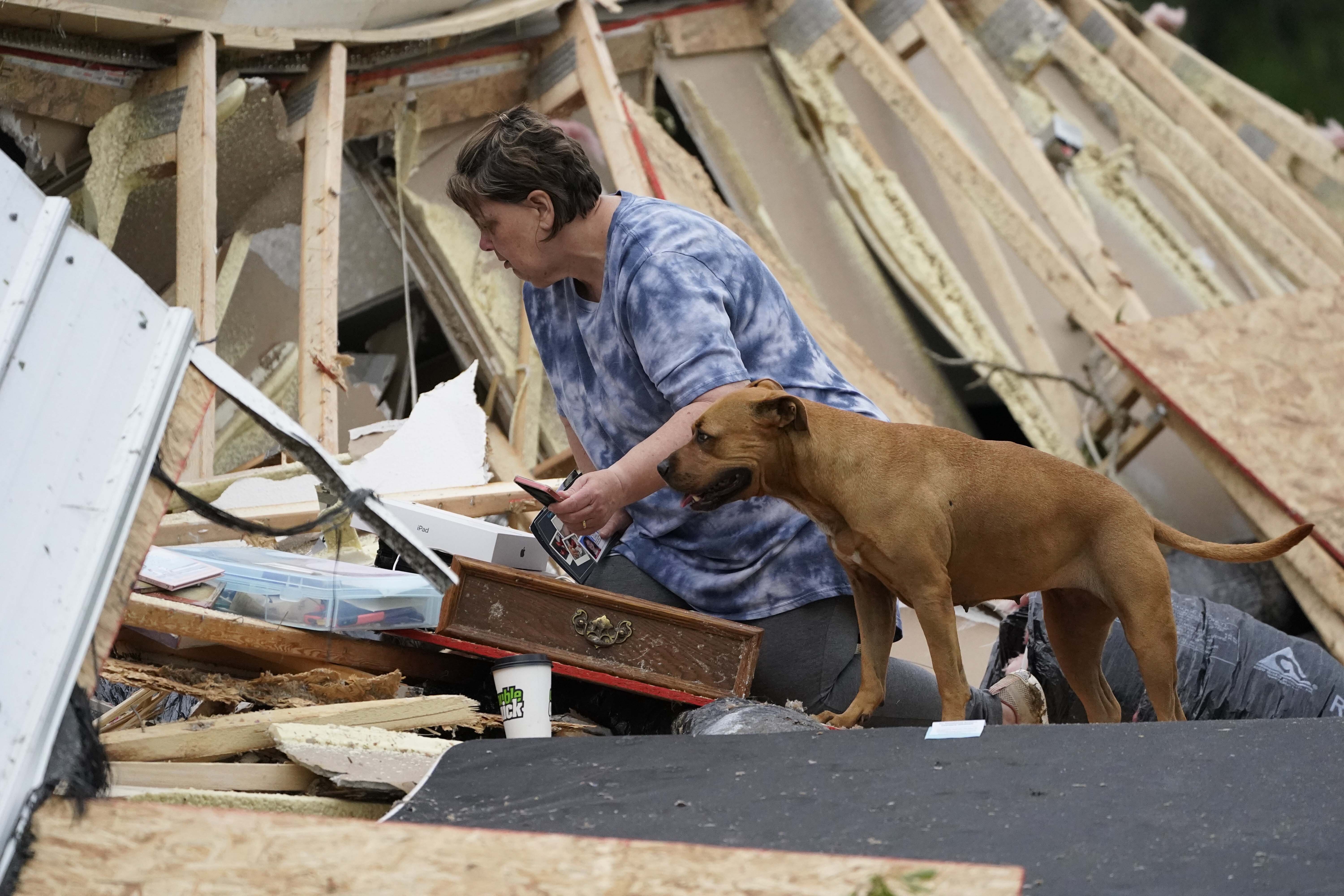 Vickie Savell looks through her belongings amid the remains of her new mobile home early Monday, May 3, 2021, in Yazoo County, Miss. (AP Photo/Rogelio V. Solis)