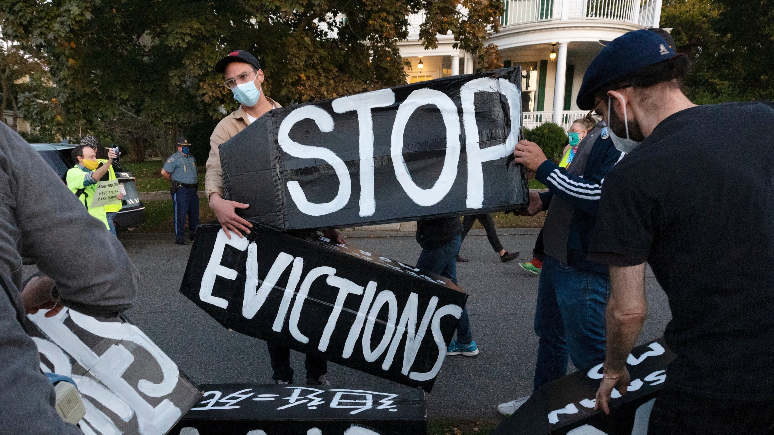 In this Oct. 14, 2020, file photo, housing activists erect a sign in front of Massachusetts Gov. Charlie Baker's house in Swampscott, Mass. (AP Photo/Michael Dwyer, File)