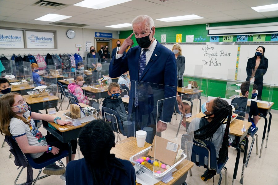 In this May 3, 2021, photo, President Joe Biden gestures as he talks to students during a visit to Yorktown Elementary School, in Yorktown, Va., as first lady Jill Biden watches. Biden has met his goal of having most elementary and middle schools open for full, in-person learning in his first 100 days. (AP Photo/Evan Vucci)