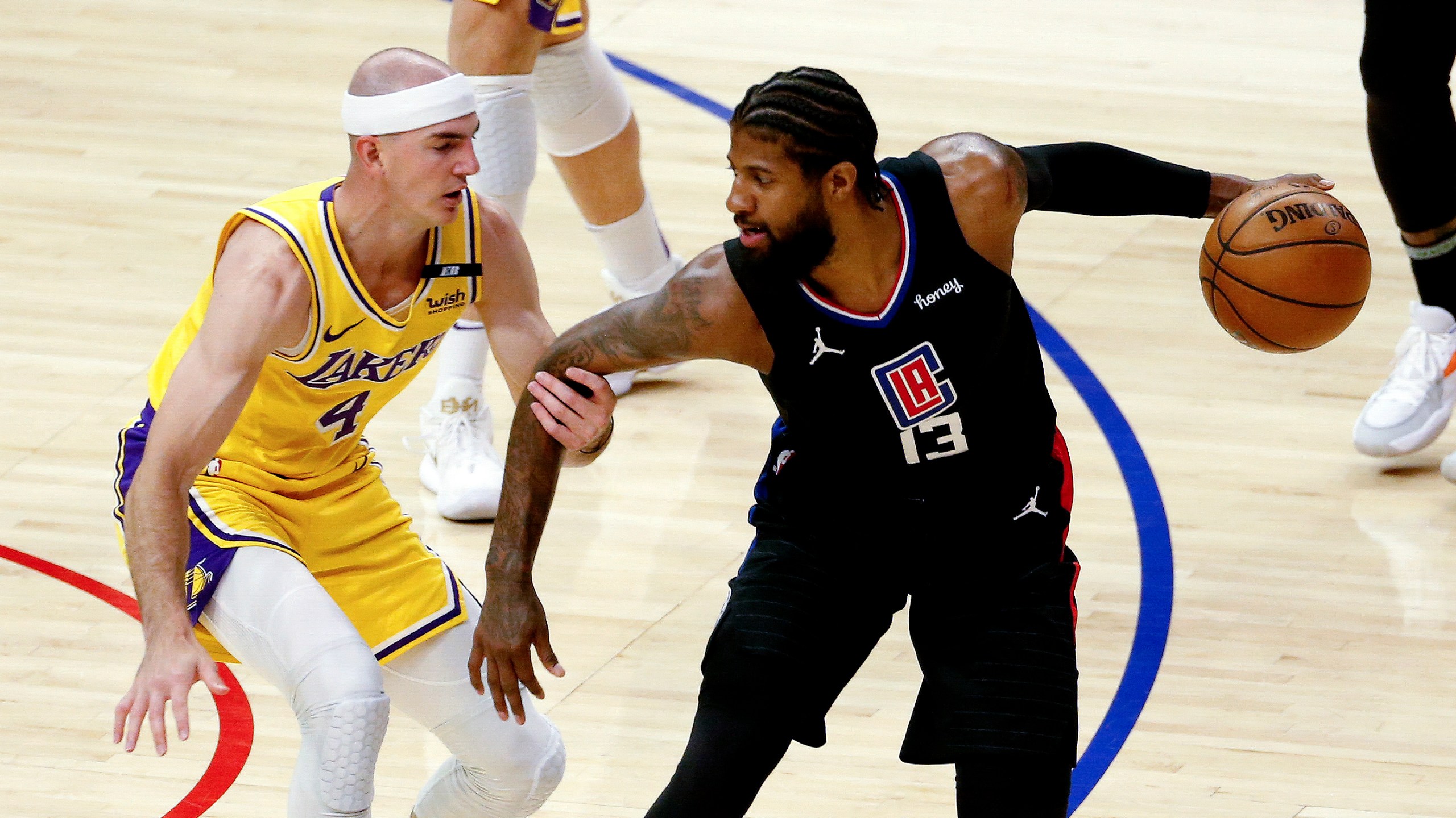 Los Angeles Clippers' Paul George is defended by Los Angeles Lakers' Alex Caruso during the first half of an NBA basketball game at the Staples Center on May 6, 2021. (Ringo H.W. Chiu / Associated Press)