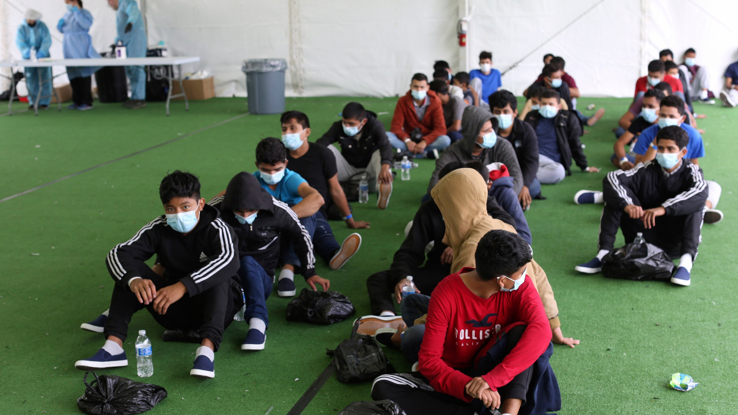 In this March 30, 2021 file photo, young migrants wait to be tested for COVID-19 at the Donna Department of Homeland Security holding facility, the main detention center for unaccompanied children in the Rio Grande Valley, in Donna, Texas. (AP Photo/Dario Lopez-Mills, Pool, File)