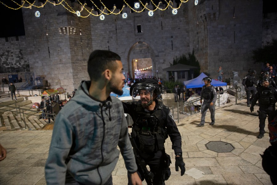 An Israeli policeman shouts at a Palestinian man to leave the Damascus Gate to the Old City of Jerusalem after clashes at the Al-Aqsa Mosque compound on May 7, 2021. (Maya Alleruzzo / Associated Press)