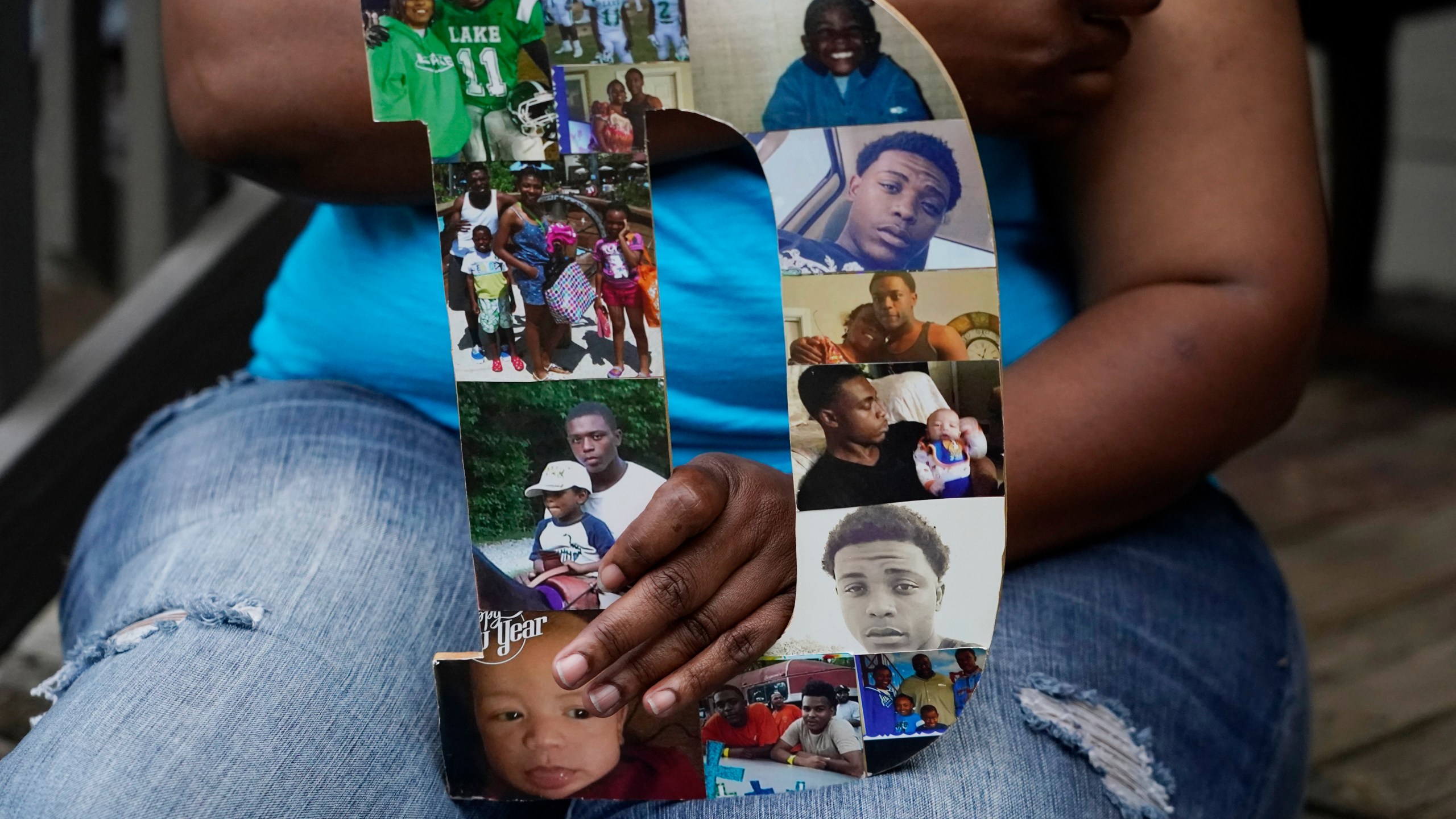 Tammie Townsend holds a collage of photographs of her eldest son, Willie Jones Jr., 21, with family members, as she speaks about the incident where he was found hanging from a tree in his girlfriend's Scott County yard three years ago, April 27, 2021 at his grandmother's home in Forest, Miss. The collage are in the form of a "D," which played off his nickname, "Duke." A Hinds County judge recently awarded the family $11 million in a civil suit related to his death. (AP Photo/Rogelio V. Solis)