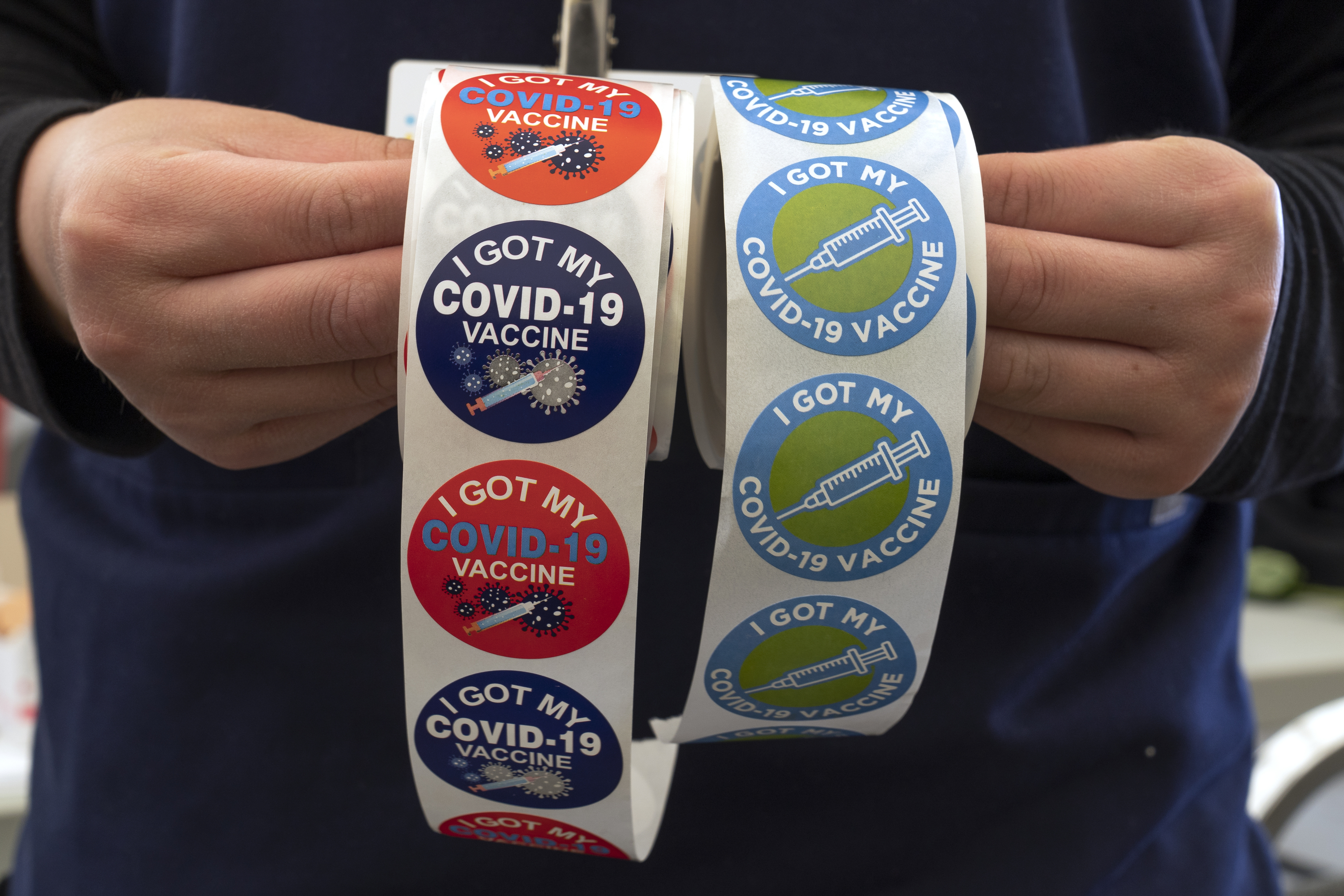 A nurse holds stickers reading "I got my COVID-19 vaccine" at the Mexican Consulate in Los Angeles during a vaccine clinic run by CHIRLA, the Coalition for Humane Immigrant Rights, on May 8, 2021.