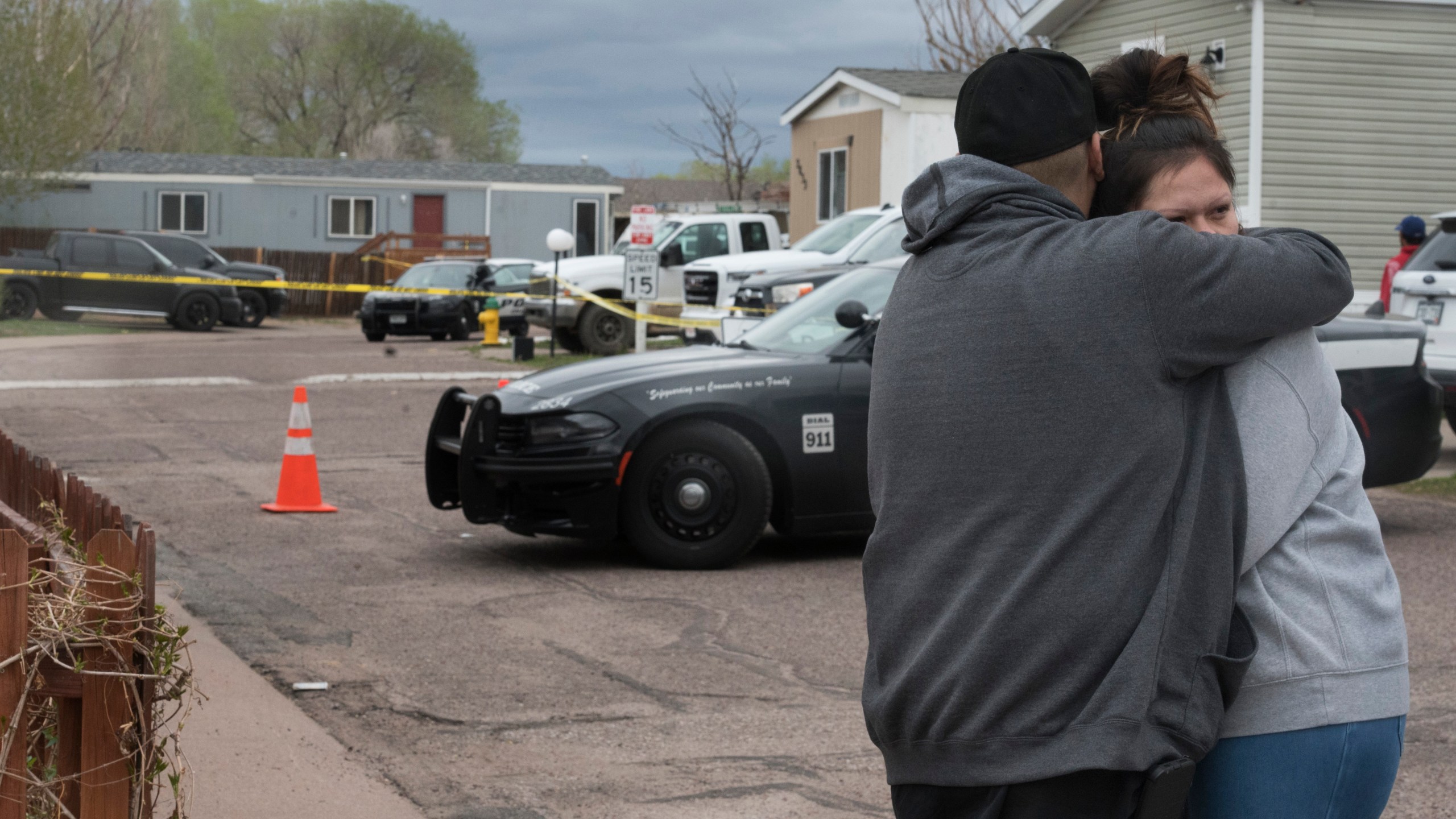 Family and friends of the victims who died in a shooting, comfort each down the street from the scene in Colorado Springs, Colo., on Sunday, May 9, 2021. The suspected shooter was the boyfriend of a female victim at the party attended by friends, family and children. He walked inside and opened fire before shooting himself, police said. Children at the attack weren’t hurt and were placed with relatives.(Jerilee Bennett/The Gazette via AP)