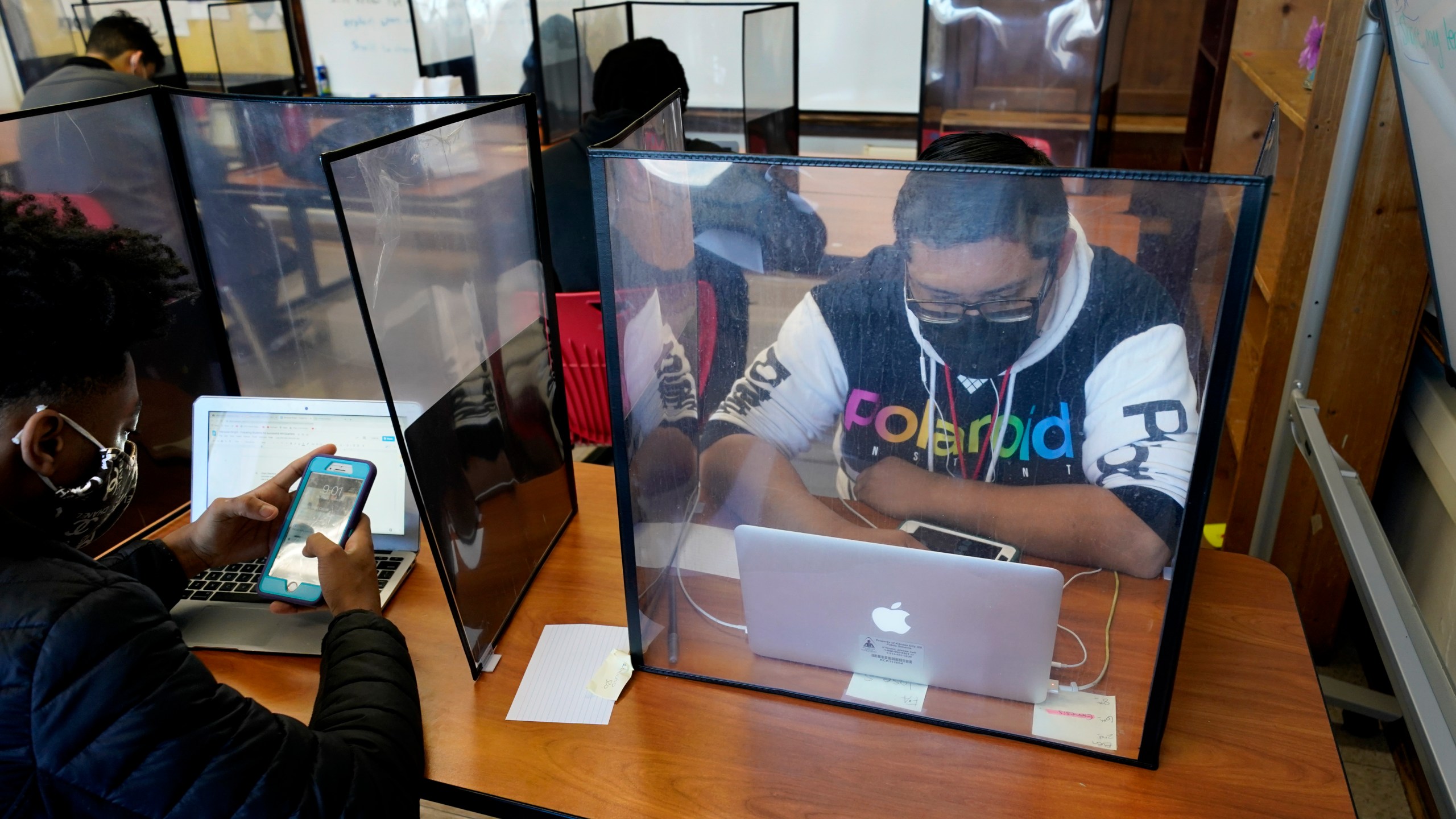 Senior Jose Solano-Hernandez, right, studies with classmates on the first day of in-person learning at Wyandotte High School in Kansas City, Kan., Wednesday, March 30, 2021. (AP Photo/Charlie Riedel)