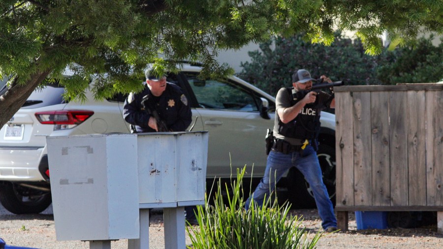 Officers take aim at an apartment across Camilla Court, Monday, May 10, 2021, in San Luis Obispo, Calif. (David Middlecamp/The Tribune (of San Luis Obispo via AP)