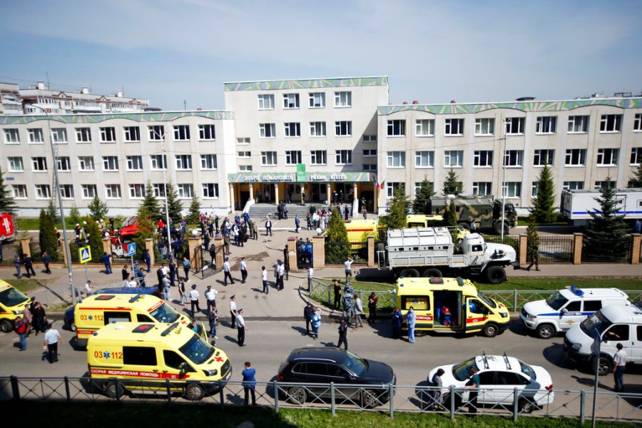 Ambulances and police cars and a truck are parked at a school after a shooting in Kazan, Russia, Tuesday, May 11, 2021. (AP Photo/Roman Kruchinin)