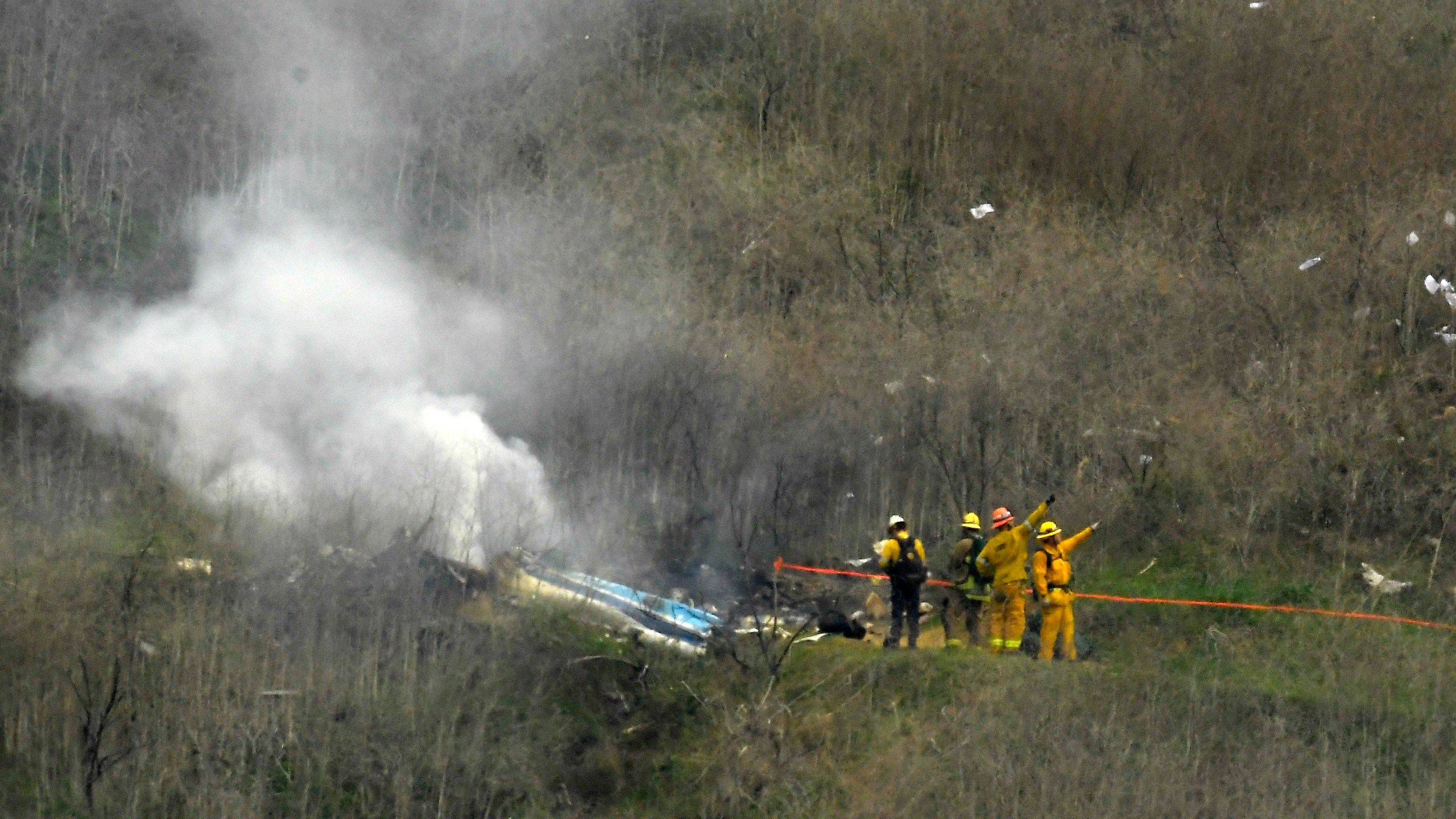 In this Jan. 26, 2020 file photo firefighters work the scene of a helicopter crash where former NBA basketball star Kobe Bryant died, in Calabasas. (Mark J. Terrill/Associated Press)