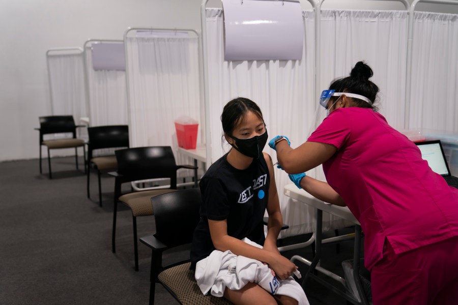 Melody Chuang, 14, receives her first dose of the Pfizer COVID-19 vaccine from medical assistant Gloria Urgell at Providence Edwards Lifesciences vaccination site in Santa Ana, Calif., Thursday, May 13, 2021. The state began vaccinating children ages 12 to 15 Thursday. (AP Photo/Jae C. Hong)