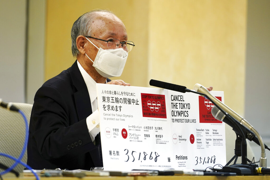 A representative of an anti-Olympics group holds boards showing the current figure of an online petition calling for the cancellation of the Tokyo 2020 Olympics and Paralympics. (AP Photo/Eugene Hoshiko)