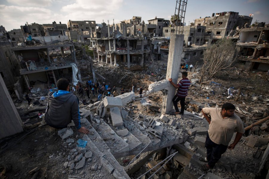 Palestinians inspect their destroyed houses following overnight Israeli airstrikes in town of Beit Hanoun, northern Gaza Strip, Friday, May 14, 2021. (AP Photo/Khalil Hamra)