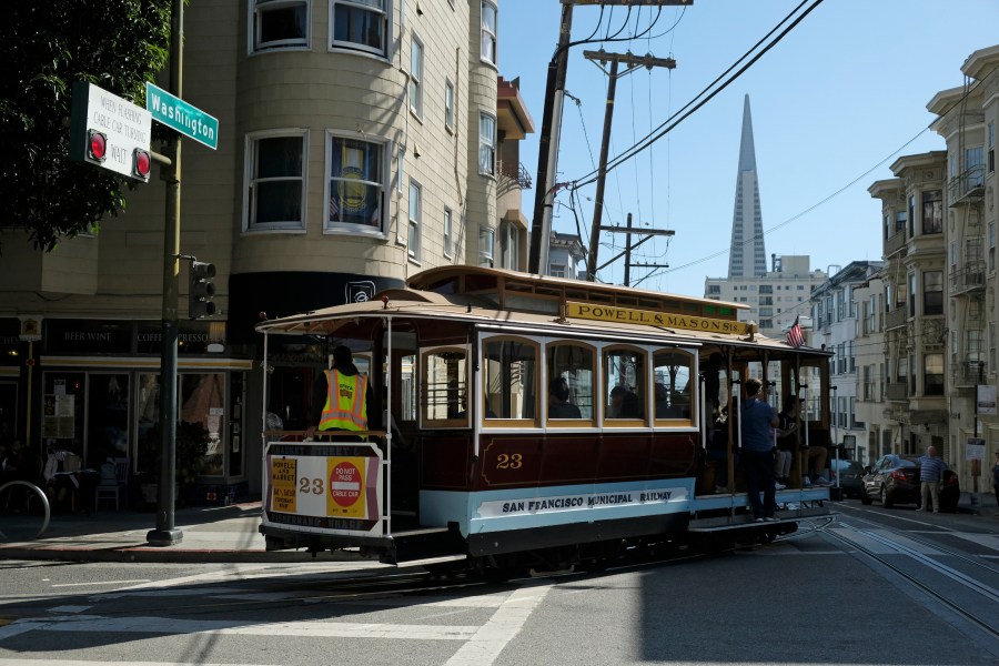 In this Sept. 11, 2019, file photo, a cable car turns onto Washington Street with the Transamerica Pyramid in the background in San Francisco. (AP Photo/Eric Risberg, File)