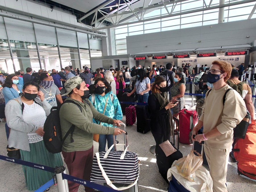 Airline passengers wait to check-in at George Bush Intercontinental Airport Sunday, May 16, 2021, in Houston. (AP Photo/David J. Phillip)