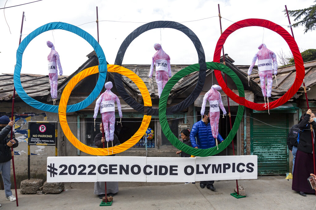 In this Feb. 3, 2021, file photo, exile Tibetans use the Olympic Rings as a prop as they hold a street protest against the holding of the 2022 Beijing Winter Olympics, in Dharmsala, India.