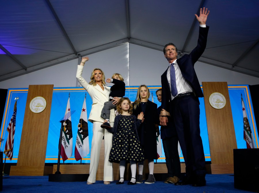 In this Jan. 7, 2019, file photo California Governor Gavin Newsom his wife, Jennifer Siebel Newsom, and their children wave after taking the oath office during his inauguration as 40th Governor of California, in Sacramento, Calif. (AP Photo/Rich Pedroncelli, File)