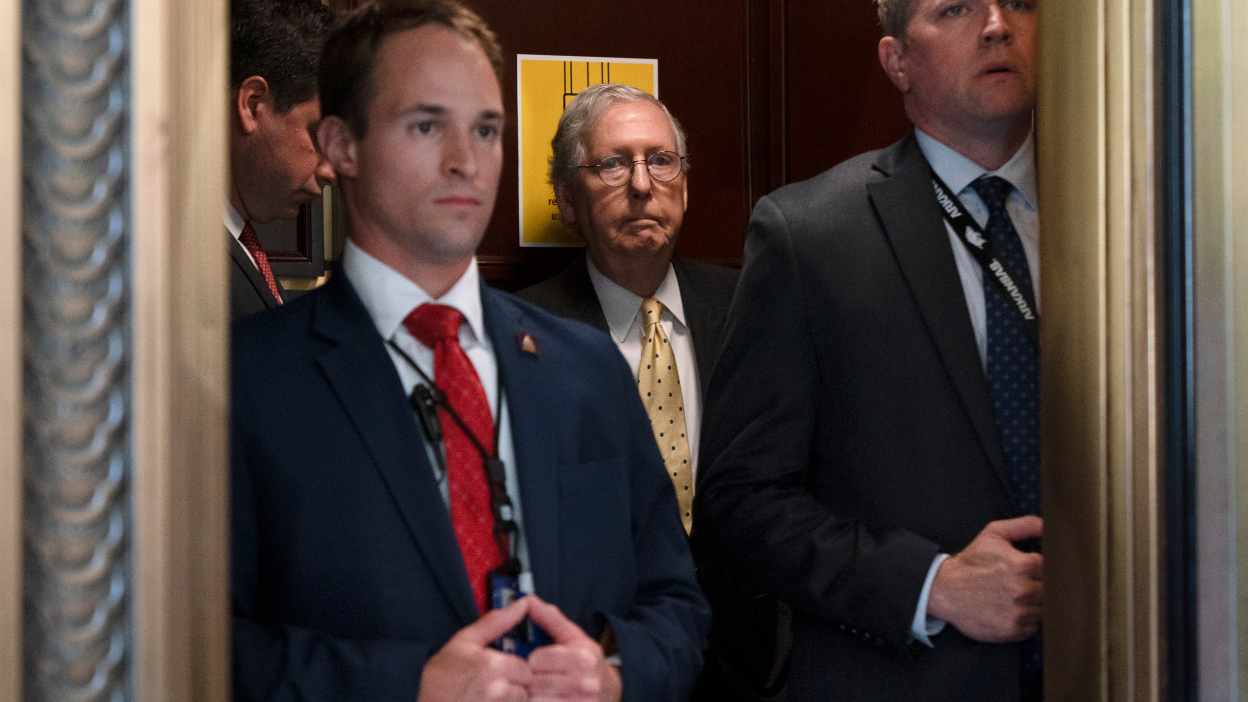 Senate Minority Leader Mitch McConnell of Ky., center, takes an elevator, Tuesday, May 18, 2021, after a meeting with Senate Republicans on Capitol Hill in Washington. (AP Photo/Jacquelyn Martin)