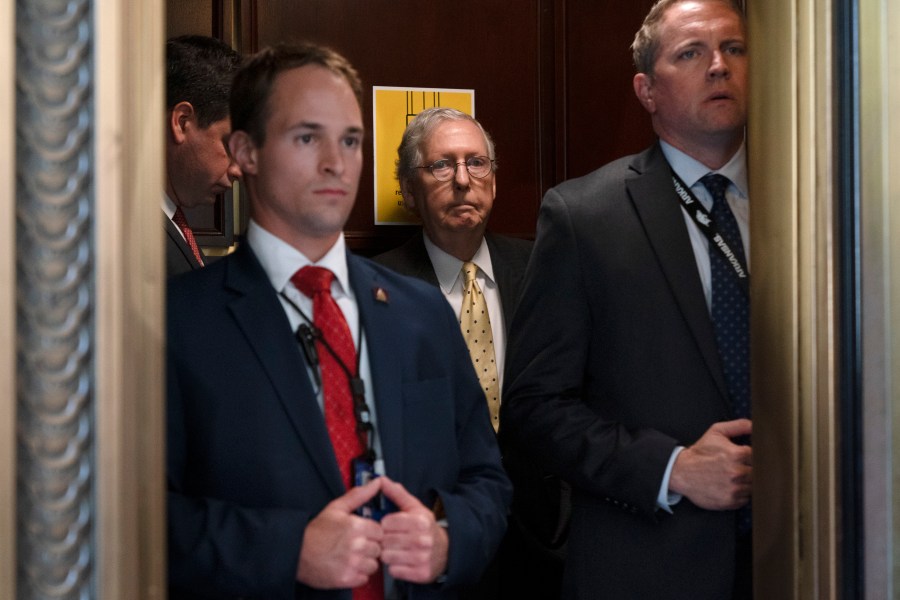 Senate Minority Leader Mitch McConnell of Ky., center, takes an elevator, Tuesday, May 18, 2021, after a meeting with Senate Republicans on Capitol Hill in Washington. (AP Photo/Jacquelyn Martin)