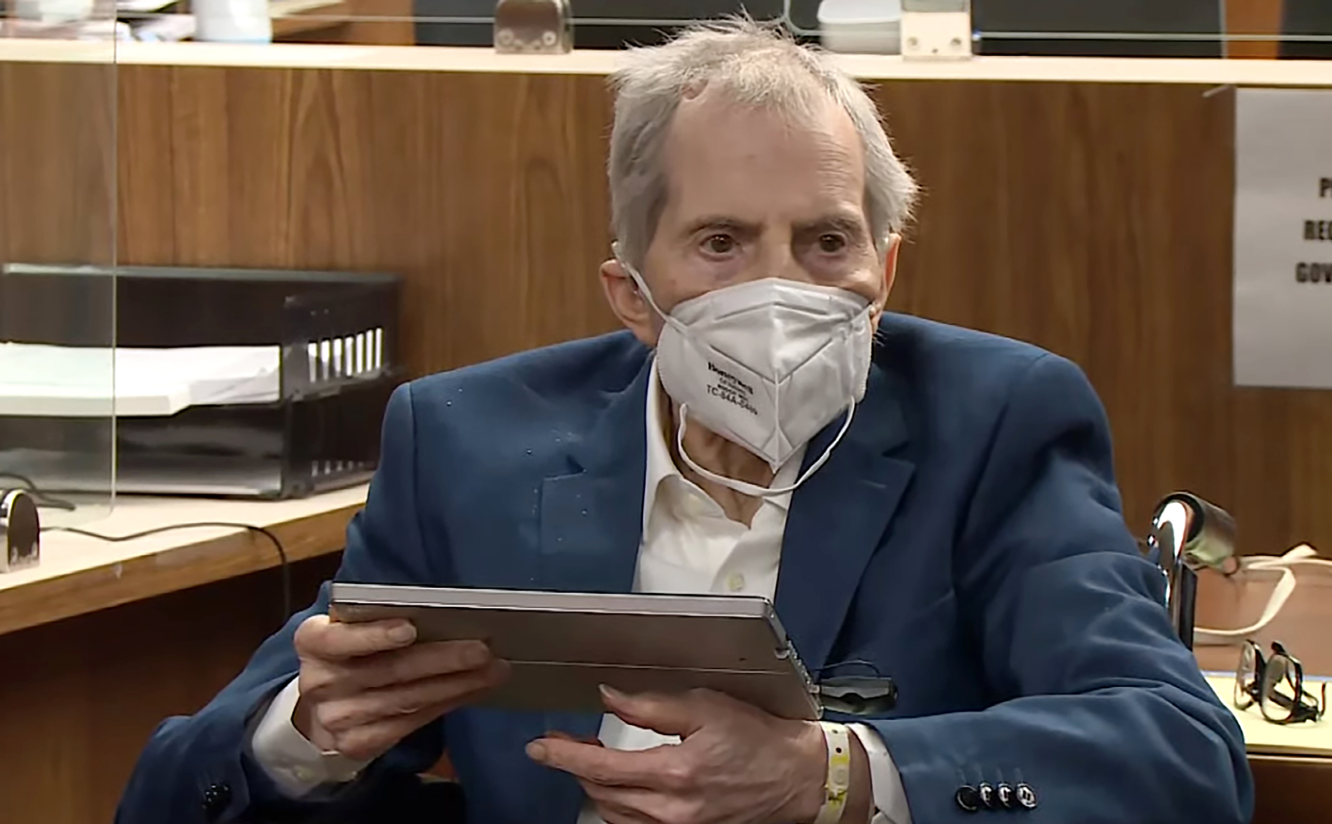 In this still image taken from the Law & Crime Network court video, real estate heir Robert Durst watches as Deputy District Attorney John Lewin presents a new round of opening statements in the murder case against Durst after a 14-month recess due to the coronavirus pandemic in Los Angeles County Superior Court in Inglewood on May 18, 2021. (Law & Crime Network via Associated Press, Pool)