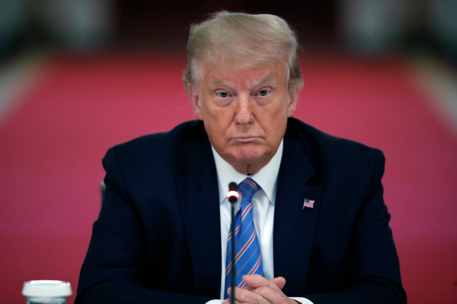 In this Tuesday, July 7, 2020 file photo, President Donald Trump listens during a "National Dialogue on Safely Reopening America's Schools," event in the East Room of the White House in Washington. The New York attorney general’s office said Tuesday, May 18, 2021 that it is conducting a criminal investigation into former President Donald Trump’s business empire, expanding what had previously been a civil probe. Attorney General Letitia James investigators are working with the Manhattan district attorney’s office, which has been conducting a criminal investigation into Trump and his company, the Trump Organization, for two years. (AP Photo/Alex Brandon, File)