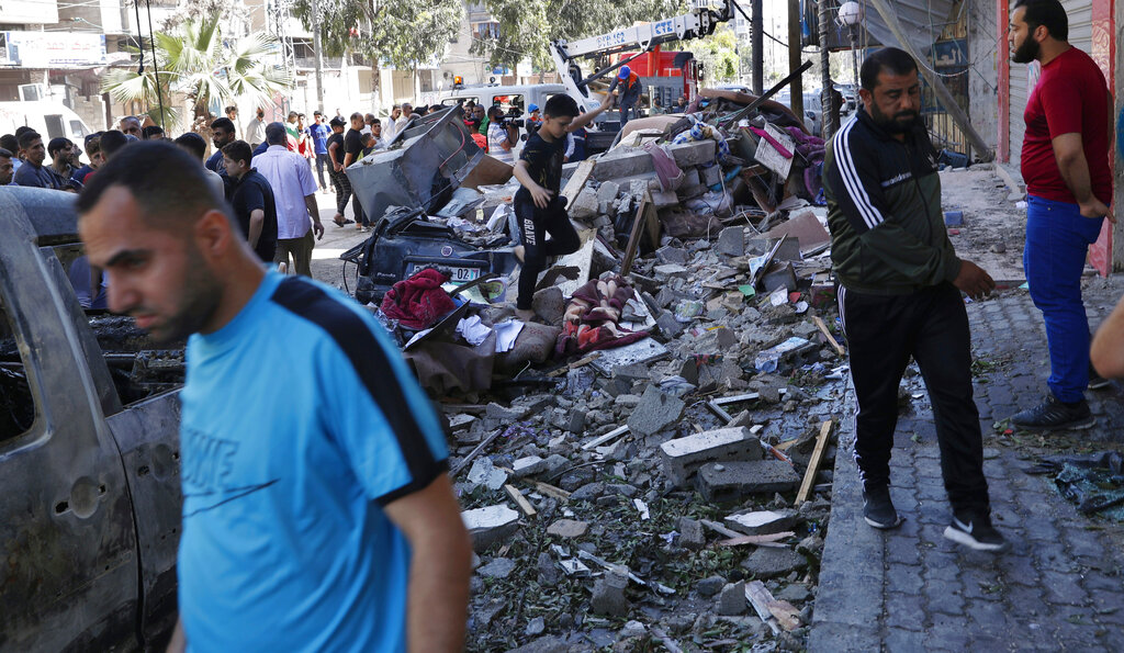 People inspect the rubble of destroyed the Abu Hussein building that was hit by an Israeli airstrike early morning, in Gaza City, Wednesday, May 19, 2021. (AP Photo/Adel Hana)