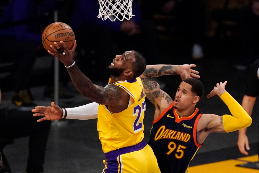 Los Angeles Lakers forward LeBron James, left, shoots as Golden State Warriors forward Juan Toscano-Anderson defends during the first half of an NBA basketball Western Conference Play-In game on May 19, 2021, in Los Angeles. (AP Photo/Mark J. Terrill)