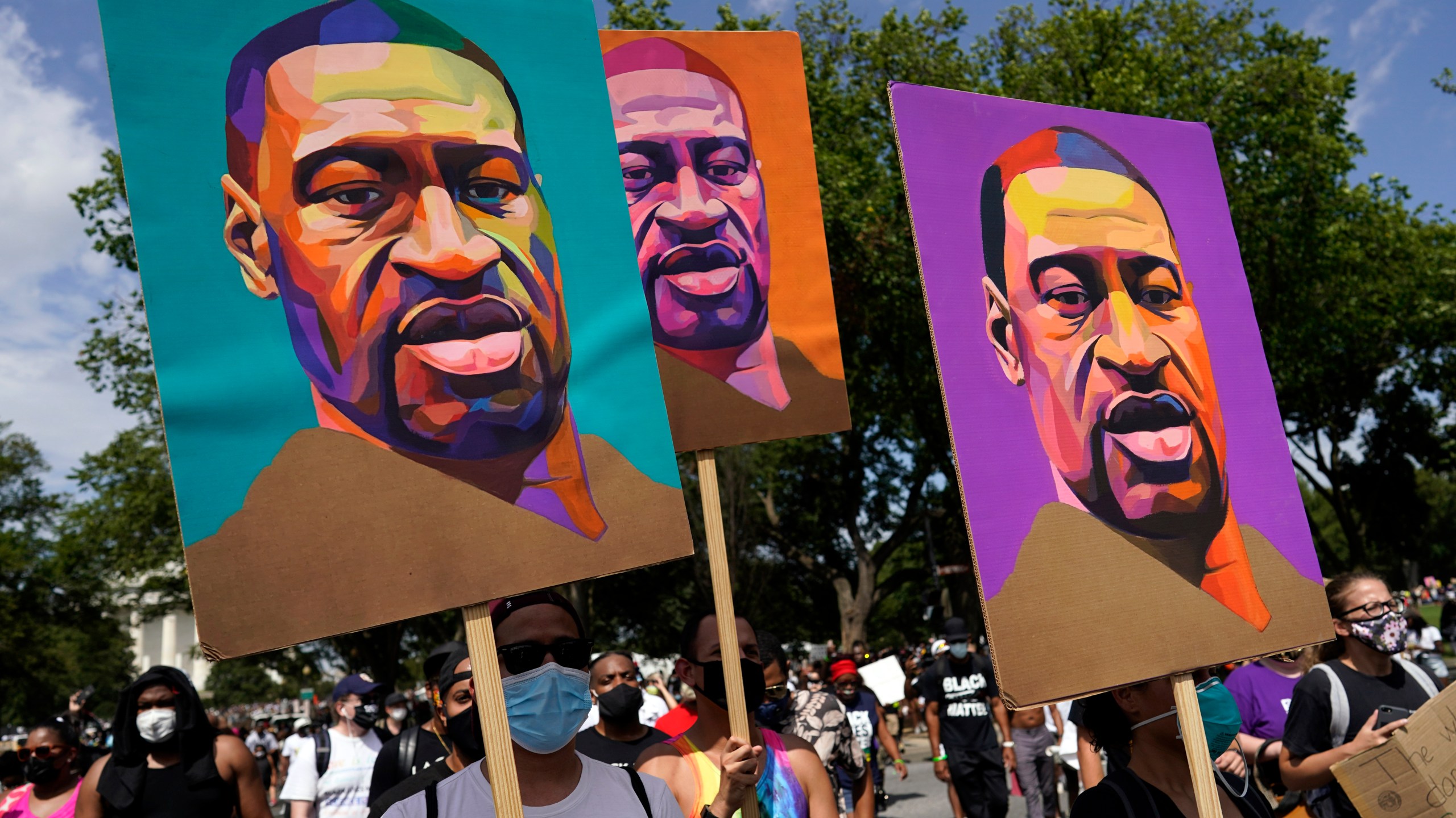 In this Aug. 28, 2020, file photo, people carry posters with George Floyd on them as they march from the Lincoln Memorial to the Martin Luther King Jr. Memorial in Washington. As the anniversary of George Floyd’s murder approaches, some people say the best way to honor him is for Congress to pass a bill in his name that overhauls policing. (AP Photo/Carolyn Kaster, File)