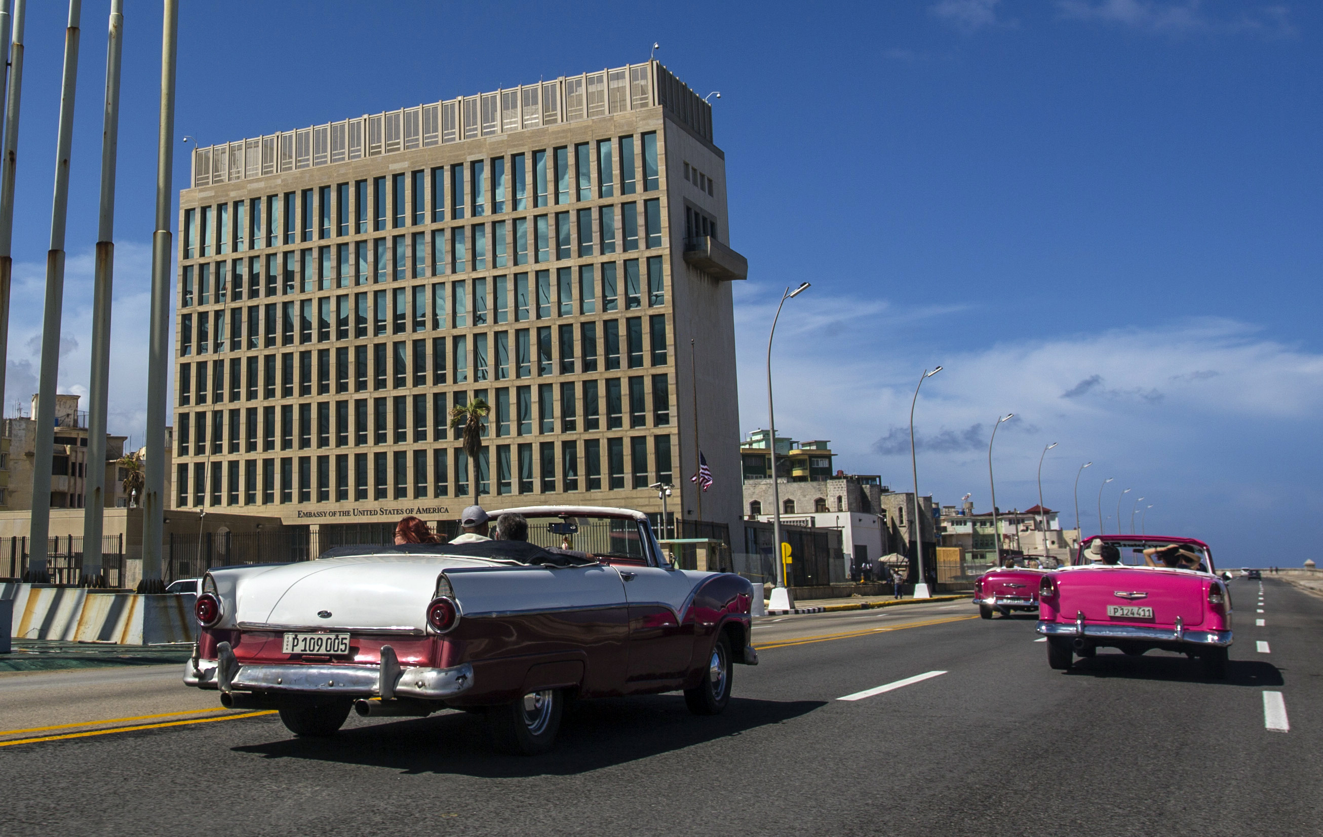 In this Oct. 3, 2017, file photo, tourists ride classic convertible cars on the Malecon beside the United States Embassy in Havana, Cuba. The Biden administration faces increasing pressure to respond to a sharply growing number of reported injuries suffered by diplomats, intelligence officers and military personnel that some suspect are caused by devices that emit waves of energy that disrupt brain function. The problem has been labeled the “Havana Syndrome,” because the first cases affected personnel in 2016 at the U.S. Embassy in Cuba. (AP Photo/Desmond Boylan, File)