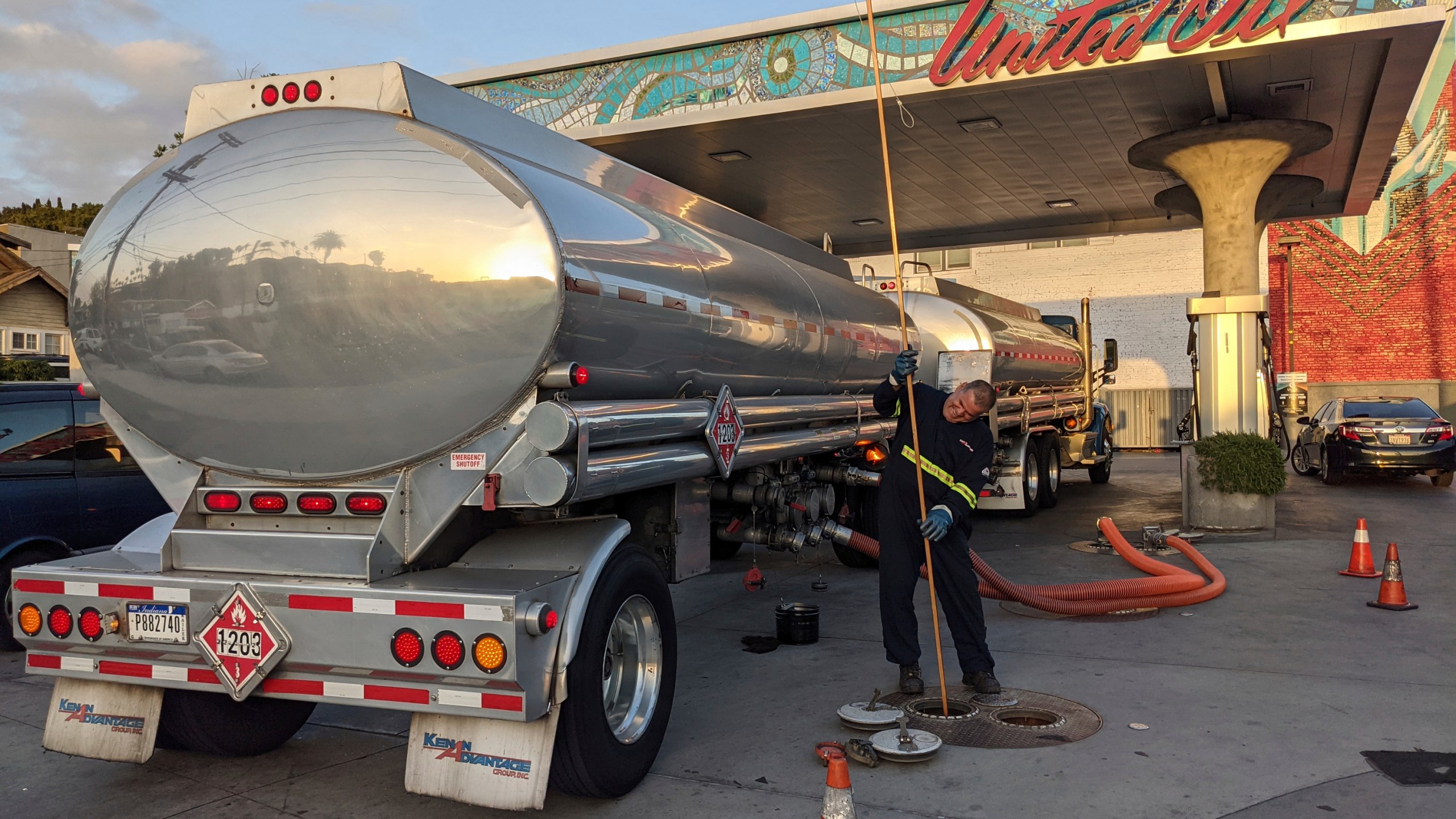 In this May 20, 2021 photo, a fuel truck driver checks the gasoline tank level at a United Oil gas station in Sunset Blvd., in Los Angeles. (AP Photo/Damian Dovarganes)