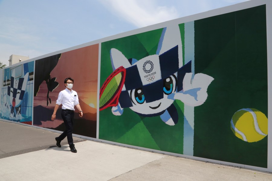 A man walks by posters promoting the Olympic Games planned to start in the summer of 2021, in Tokyo, Monday, May 24, 2021. (AP Photo/Koji Sasahara)