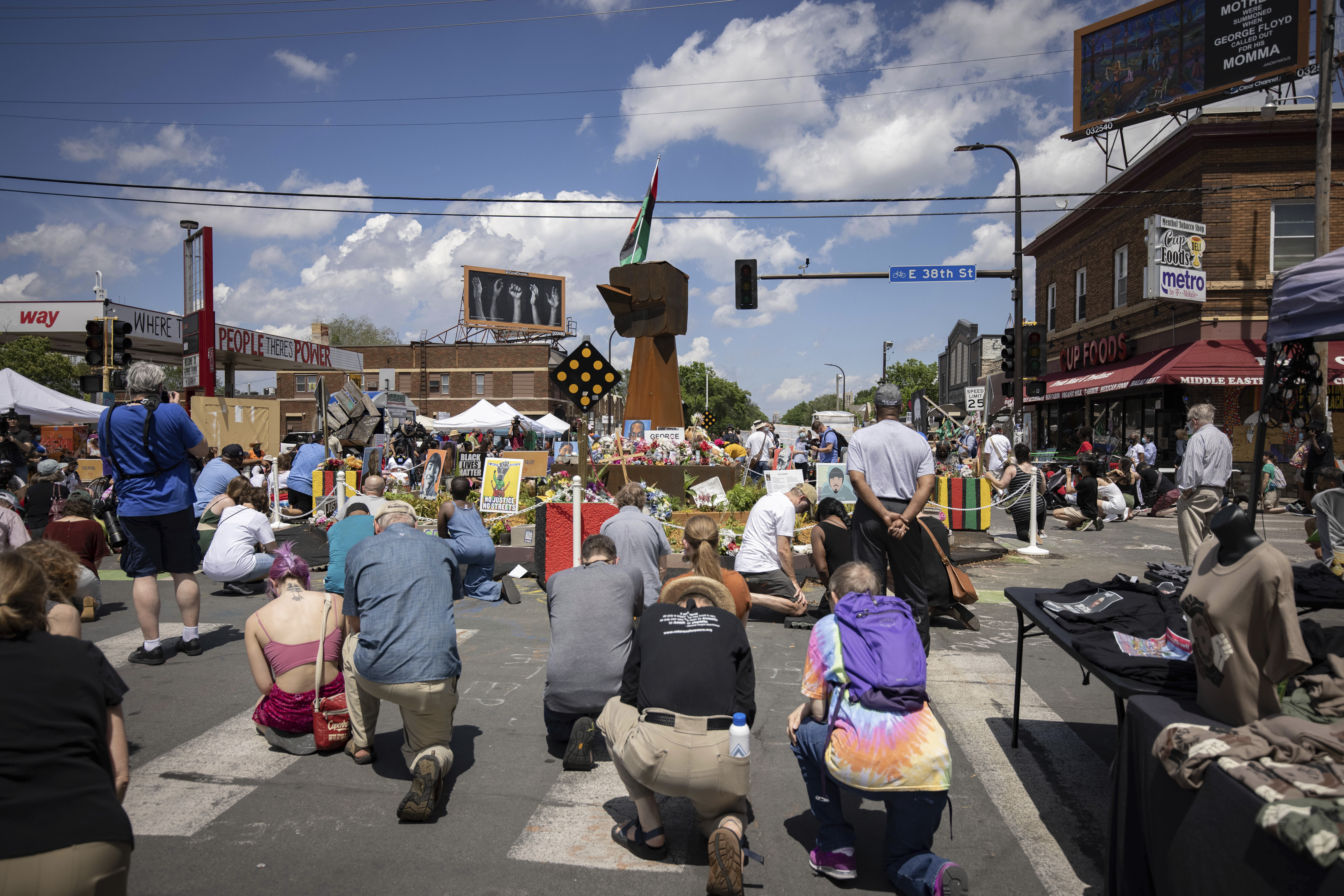 People take a knee during a moment of silence on the one year anniversary of George Floyd's death on May 25, 2021, in Minneapolis, Minn. (Christian Monterrosa / Associated Press)