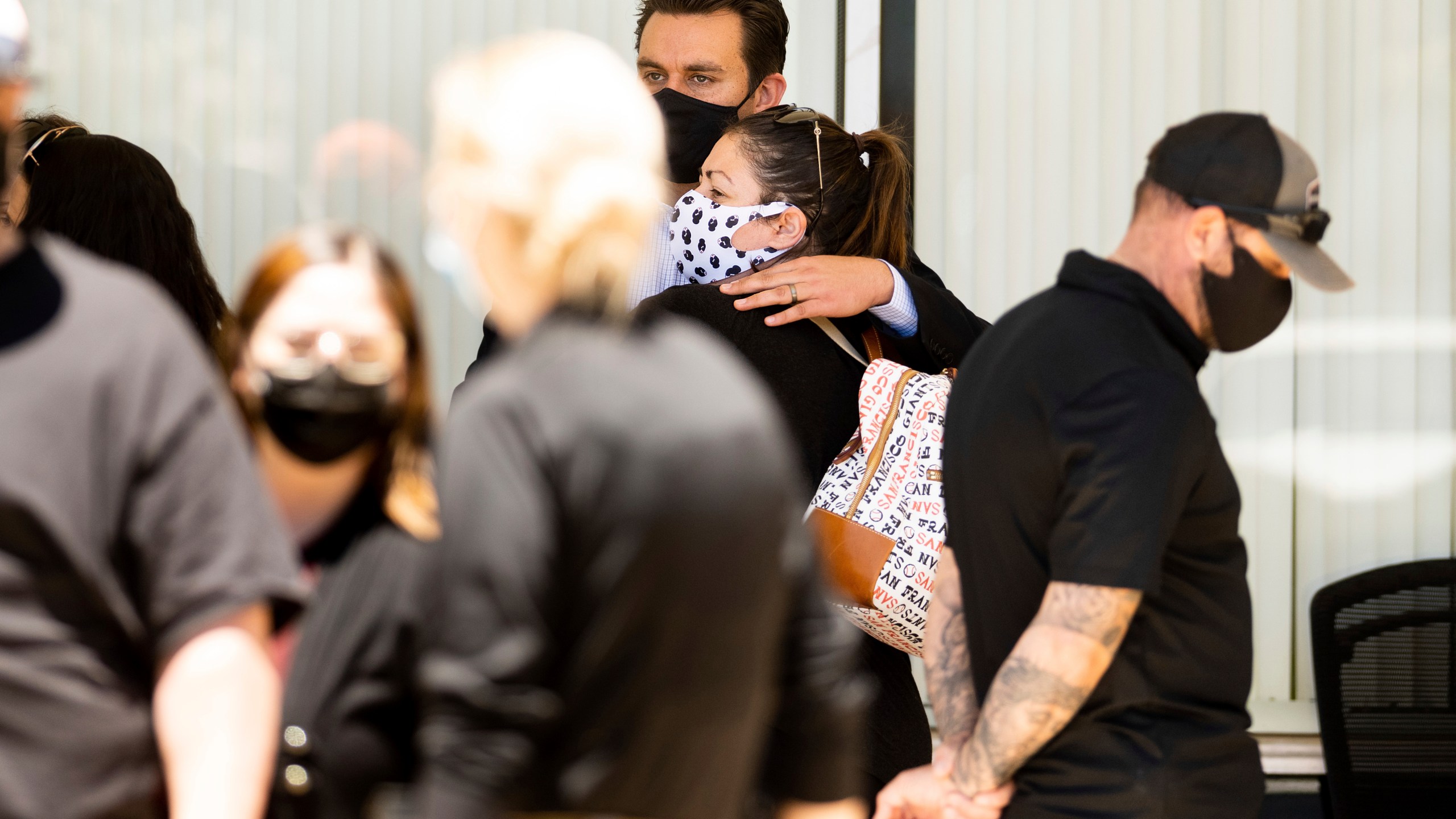 People embrace outside a staging area for Santa Clara Valley Transportation Authority (VTA) workers, family members and officials following a shooting at one of the agency's rail yards on May 26, 2021, in San Jose, Calif. (Noah Berger / Associated Press)