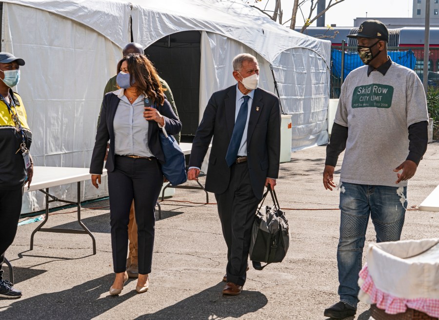 In this Feb. 4, 2021, file photo, Jeff Page, a homelessness activist, walks with U.S. District Court Judge David O. Carter, middle, and Michele Martinez, special master on the issues of homelessness, after a court hearing at Downtown Women's Center in Los Angeles. (AP Photo/Damian Dovarganes, File)