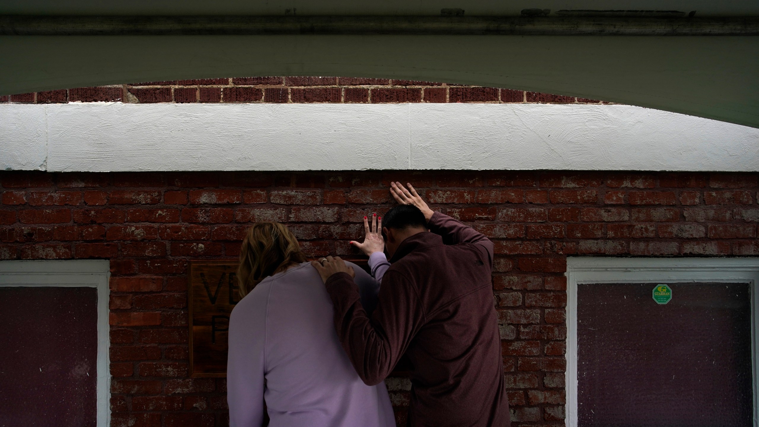 Faith Hailey, left, and Brian Hailey touch hold their hands on a prayer wall outside of the historic Vernon African Methodist Episcopal Church in the Greenwood neighborhood during the centennial of the Tulsa Race Massacre, Monday, May 31, 2021, in Tulsa, Okla. (AP Photo/John Locher)