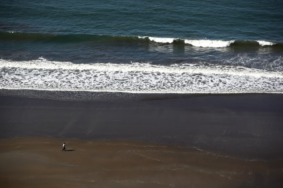 A view of a women walking on Stinson Beach, which is closed because of the Coronavirus (COVID-19), on April 01, 2020 in Stinson Beach, California. (Ezra Shaw/Getty Images)