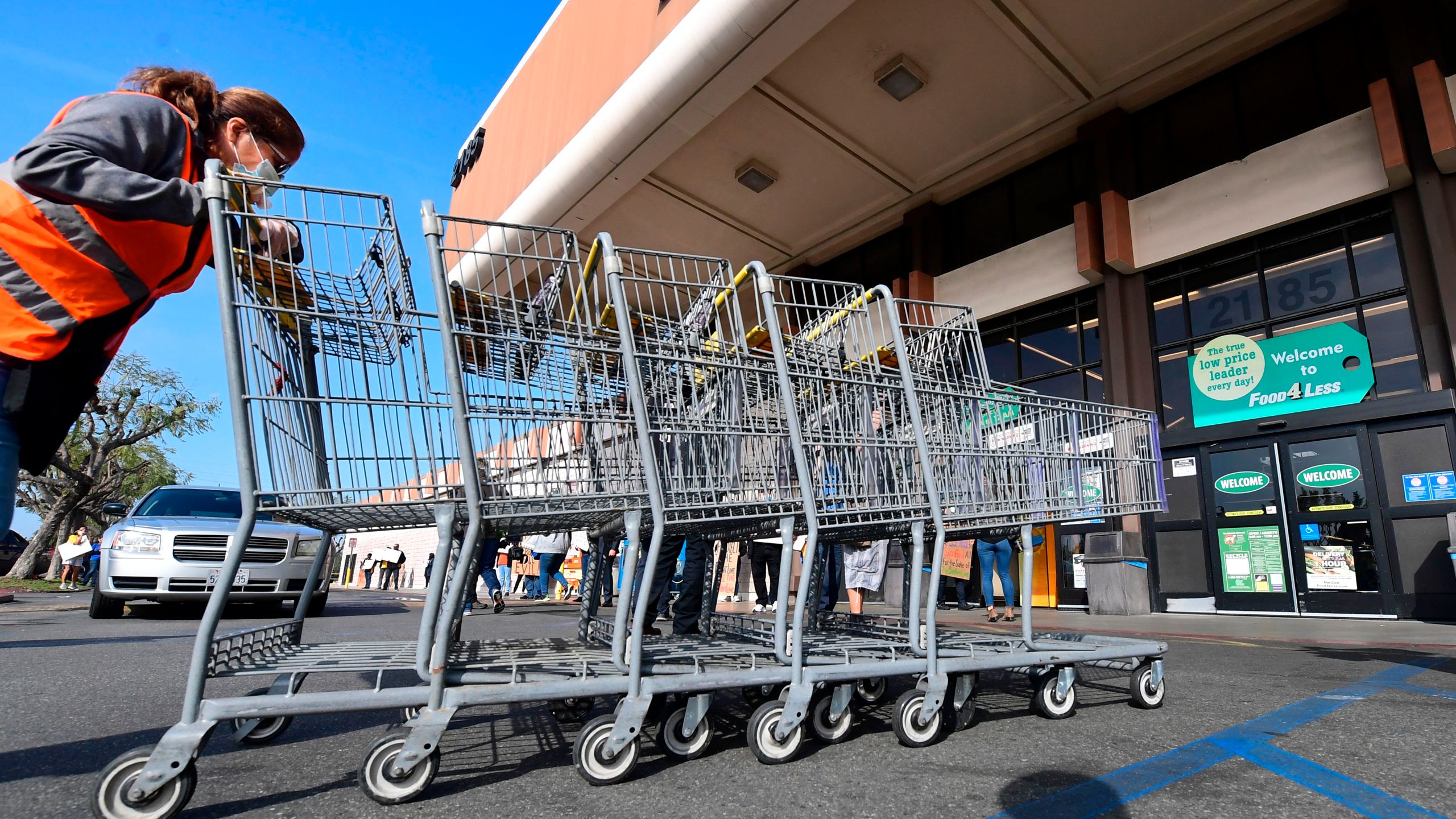 A Food 4 Less employee pushes carts in Long Beach on Feb. 3, 2021. (FREDERIC J. BROWN/AFP via Getty Images)