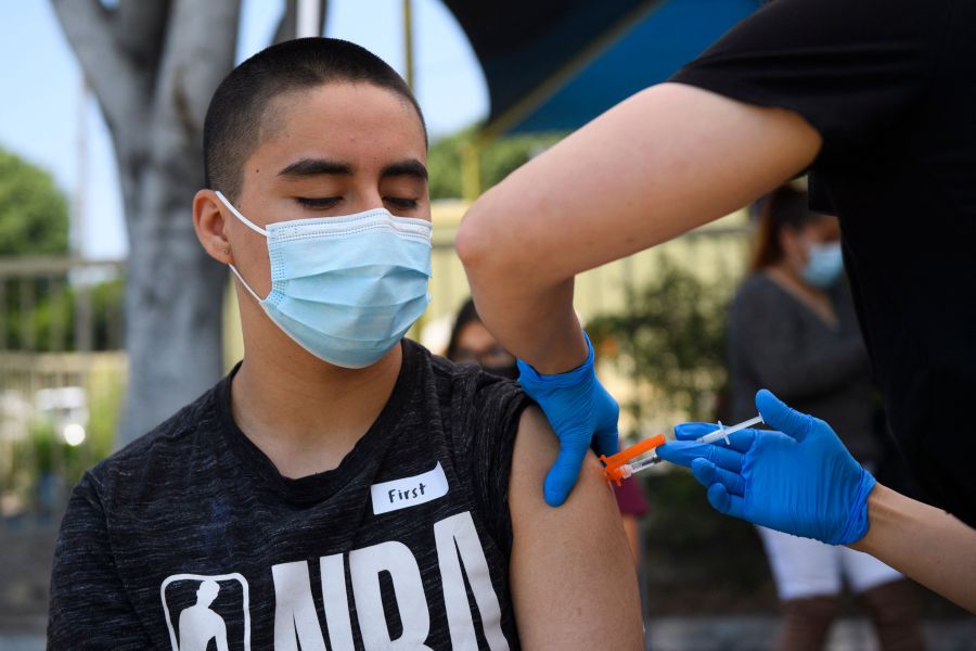 Hector Garnica, 13, receives a first dose of the Pfizer Covid-19 vaccine at a mobile vaccination clinic at the Weingart East Los Angeles YMCA on May 14, 2021 in Los Angeles, California. (PATRICK T. FALLON/AFP via Getty Images)