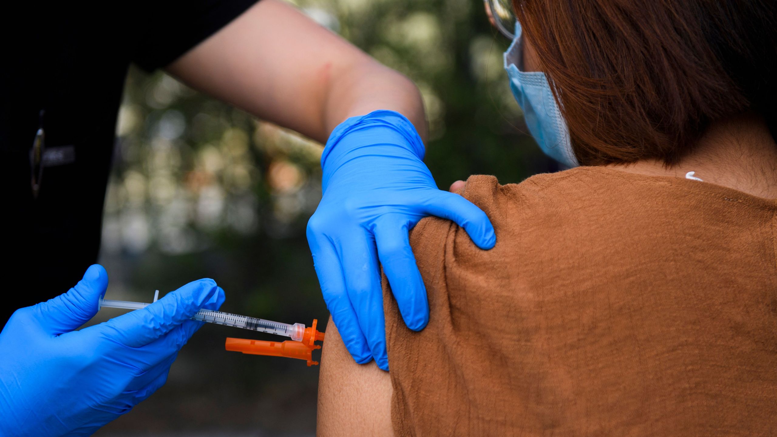 A 15-year-old receives a first dose of the Pfizer COVID-19 vaccine at a mobile vaccination clinic at the Weingart East Los Angeles YMCA on May 14, 2021. (Patrick T. Fallon / AFP / Getty Images)