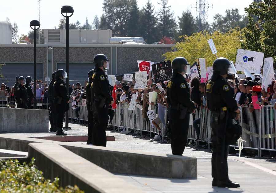 Sonoma County sheriff's deputies line up in front of protestors during a rally in front of the Sonoma County sheriff's office for 13 year-old Andy Lopez, who was shot by a Sonoma County sheriff's deputy the week prior, on Oct. 29, 2013, in Santa Rosa. (Justin Sullivan/Getty Images)