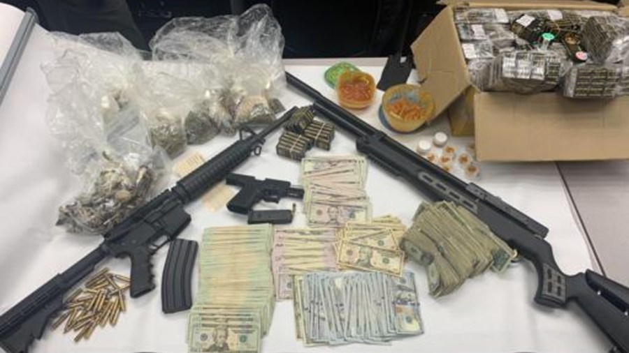 Police released this photo of guns, drugs and cash they say was recovered at a home where a child accidentally shot himself on May 25, 2021.